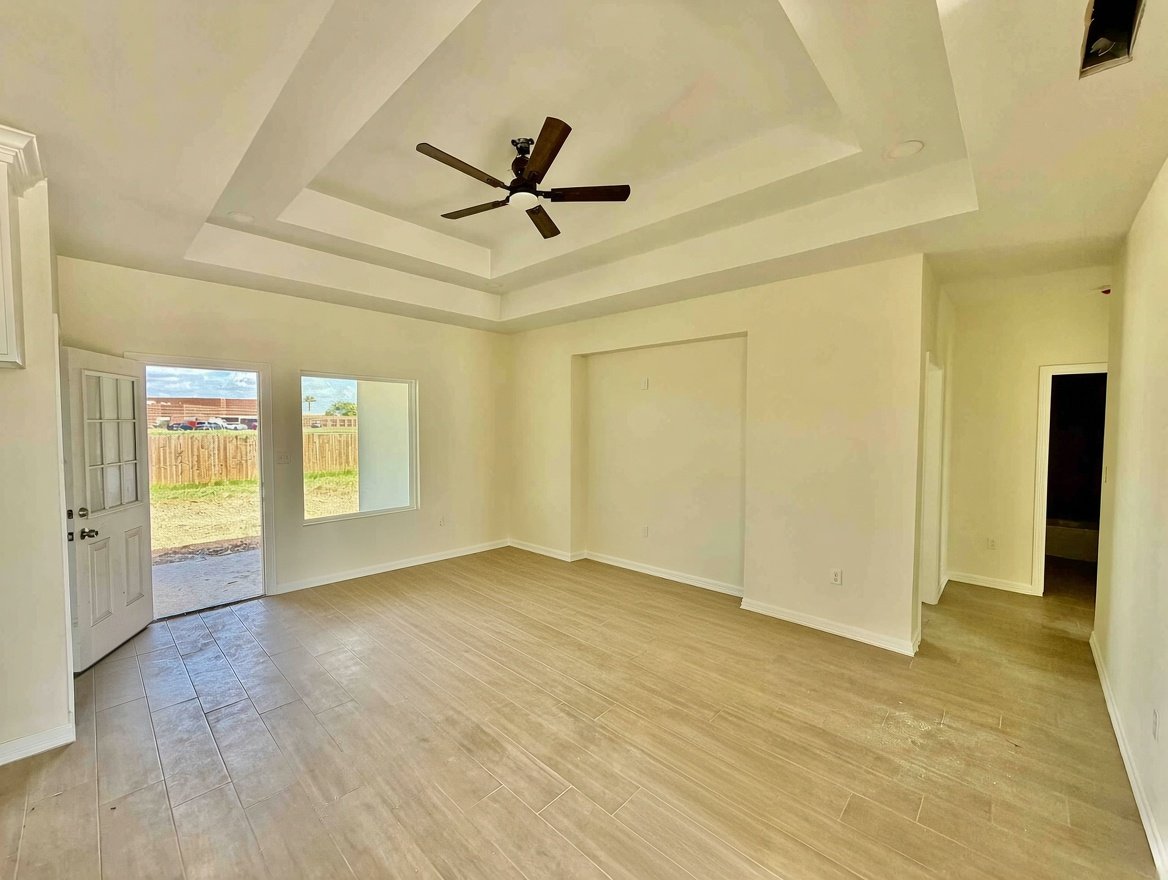 Living area at 224 Sauvignon Ave with tray ceiling and backyard access, San Benito TX